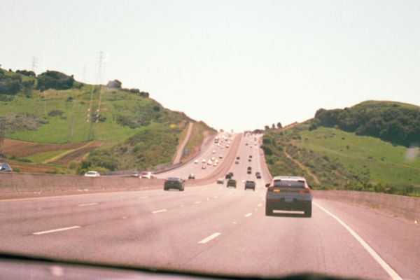 Autobahn mit vielen Autos und grünen Hügeln