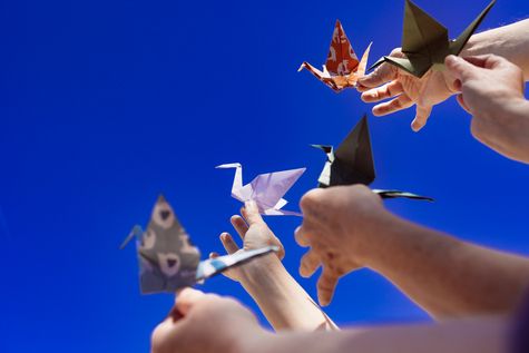 Gefaltete Kraniche vor blauem Himmel