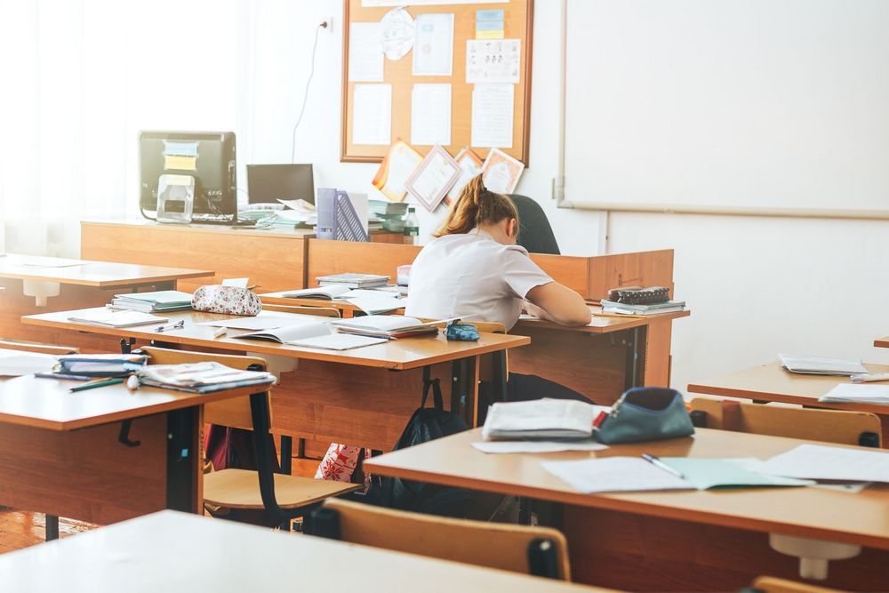 Klassenzimmer mit einer Schüler*in und vielen leeren Schultischen