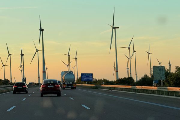 Autobahn mit vielen Windrädern und Sonnenuntergang