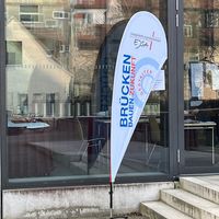 Beachflag mit der Beschriftung "Brücken bauen" vor dem Tagungshaus