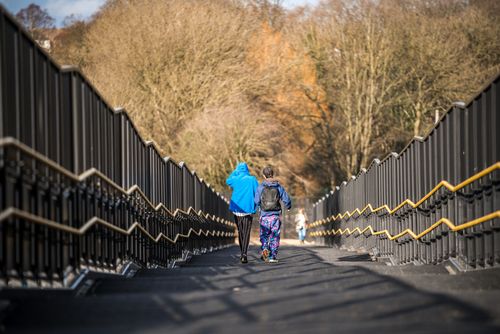Zwei junge Menschen von hinten, die eine Treppe hinuntergehen